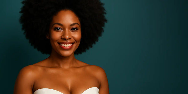 Smiling woman with natural afro hair poses against teal backdrop, featuring Keyoma branding; healthy hair, portrait.