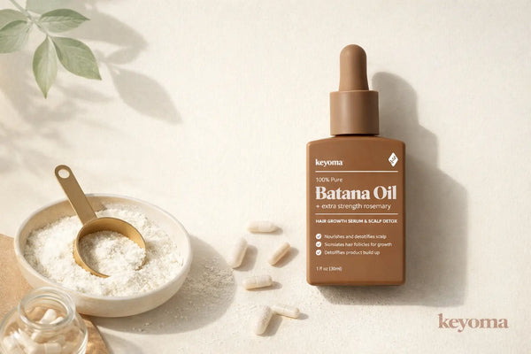 Flatlay of Keyoma Batana Oil with collagen powder bowl, capsules, and gold scoop.