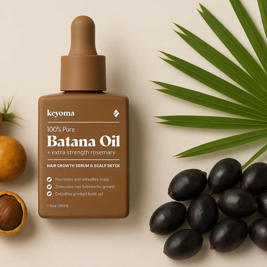 Keyoma Batana Oil with extra strength rosemary displayed alongside batana nuts, saw palmetto berries, and a palm leaf for natural hair and scalp care.